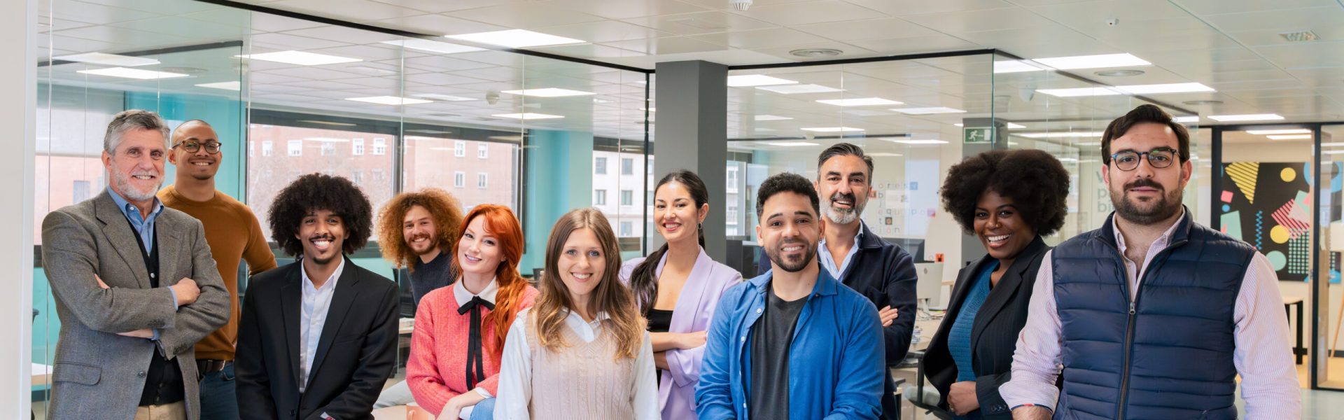 Diverse team of professionals posing together in a modern coworking office environment.